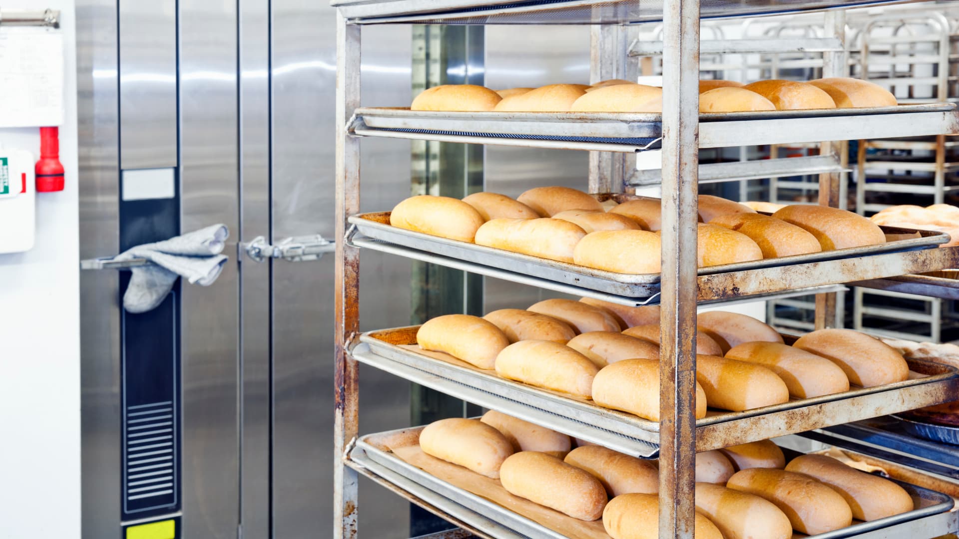An image of commercial baking equipment with bun pan racks. 