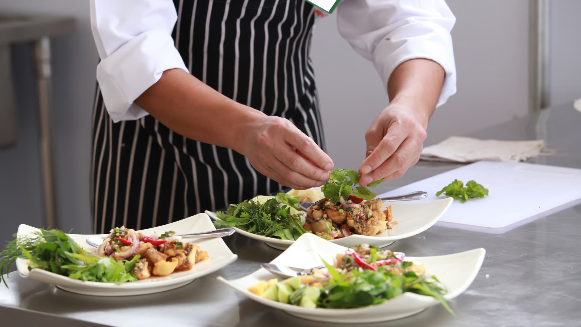 How to Open a Restaurant An image of a chef plating food in a restaurant.