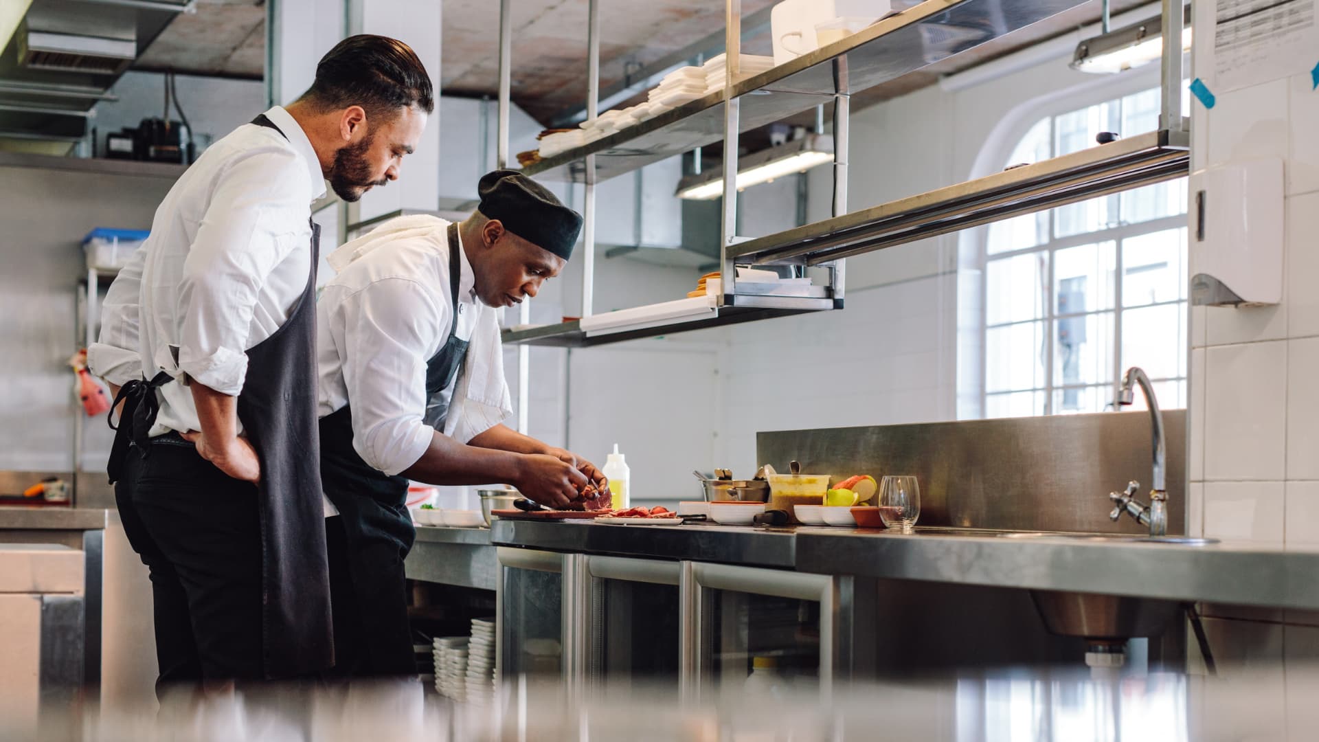 An image of chefs in a restaurant preparing a new recipe. 